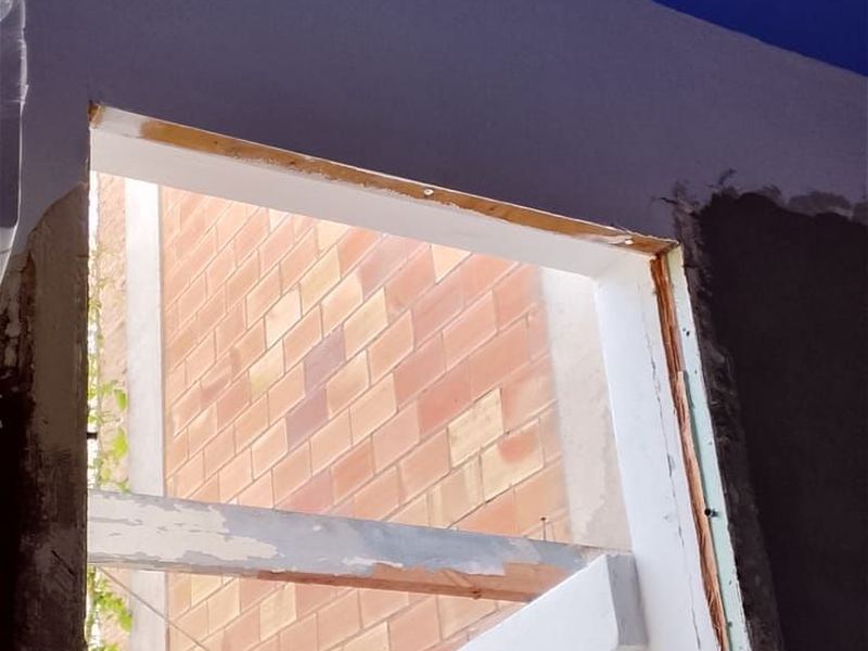 Hueco abierto en un muro de carga con el dintel y las jambas ya rematados en blanco